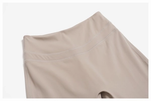 Detail of high-waisted yoga pants with reinforced flatlock stitching in sand color