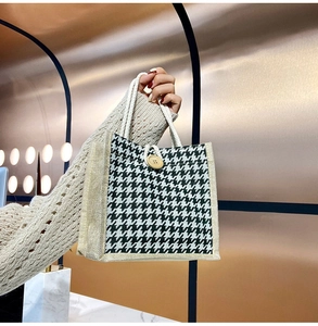 Detail of houndstooth tote bag with wooden button closure and braided rope handles