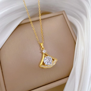 Détail du collier pendentif éventail doré avec diamant central sur fond de soie