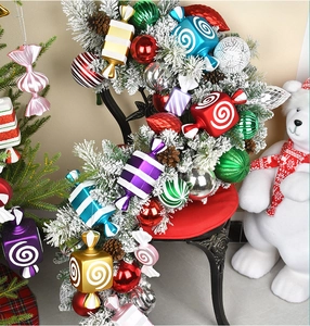 Detailed view of colorful candy-shaped ornaments hanging on snowy pine branches