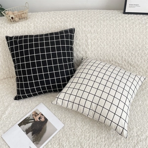 Detail of minimalist black and white checkered cotton linen cushion covers on a sofa