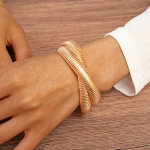 Detail of a chunky gold spiral wrap bracelet with a unique twisted metallic texture