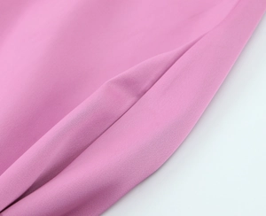 Vue macro des détails de couture de poche et texture satinée sur la robe rose