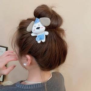 Detail shot of plush dog hair clip with blue hat and overalls worn on a hair bun