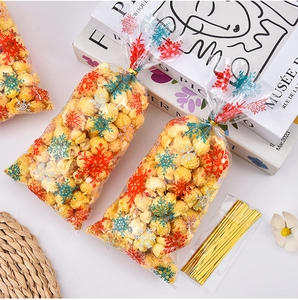 Détail de sachets de Noël à motifs de flocons avec attaches dorées pour bonbons festifs