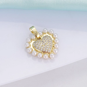 Detailed close-up of 18K gold heart pendant with pearl border and inlaid diamonds