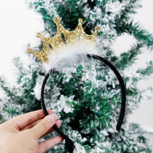Detail of gold glitter crown headband with white feather trim and holiday decor