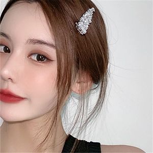 Detail of a sparkling silver hair clip with micro-set zircons worn on model side hair
