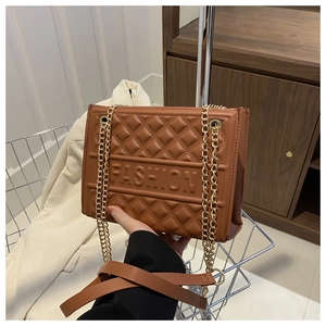 Detailed view of brown quilted PU leather handbag featuring embossed FASHION lettering