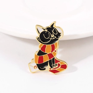 Detailed shot of a black cat enamel pin with a scarf sitting on a Christmas sock