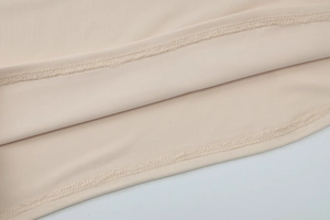 Macro shot of beige mesh fabric showing high-quality stitching and smooth texture