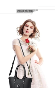 Model showcasing a chic black tote bag with silver circular buckle and adjustable strap