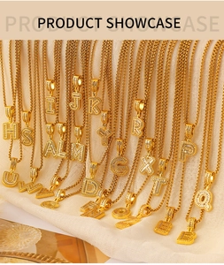 Detail of gold Cuban chain necklaces featuring sparkling A-Z crystal letter pendants