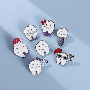 Whimsical tooth enamel pin set with Christmas hat and dental motifs on a blue background