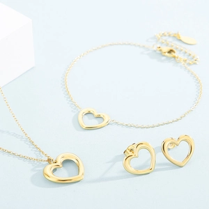 Detailed view of golden heart jewelry set with necklace bracelet and earrings