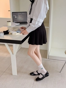 Close-up of white ribbed socks with green letter embroidery in a lifestyle setting