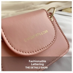 Detail of pink leather mini flap bag with gold lettering and precise stitching