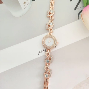 Rose gold quartz watch featuring swan link bracelet and crystal bezel on white background