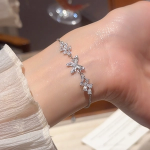 Detail of silver butterfly and flower bracelet with sparkling zircon stones on wrist