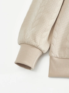 Detail of ribbed cuffs and hem on heavy jacquard quilted pullover sweatshirt