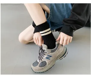 Close-up of thick combed cotton crew socks with double white stripes on the ribbed cuffs