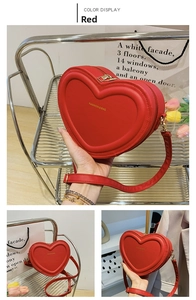 Détails macro d'un sac bandoulière en cuir rouge en forme de cœur avec zip doré