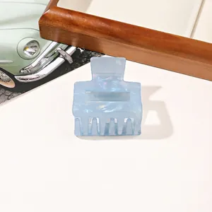 Detailed macro view of light blue square hair claw clip with iridescent marble texture