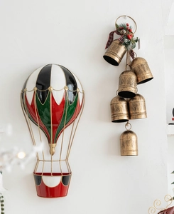 Detail of vintage Christmas wall decor with hot air balloon and golden bells with pine