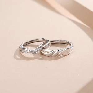 Elegant S925 silver couple rings featuring twisted band design and shimmering accents