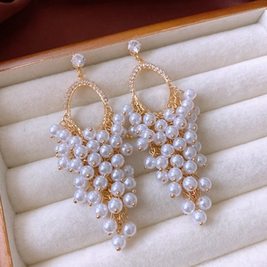 Detail of gold pearl tassel earrings with zircons and white pearls in a jewelry box