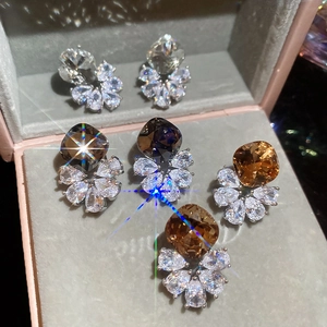 Macro shot of cushion-cut zircon earrings in clear, smoke grey and amber colors