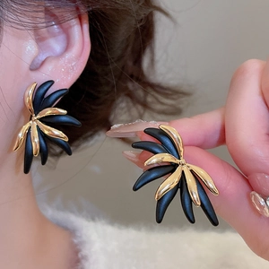 Macro detail of 18k gold plated leaf stud earrings with matte black petals and metal finish