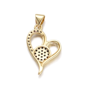 Macro shot of gold-plated heart pendant featuring a cut-out evil eye pattern with black stones