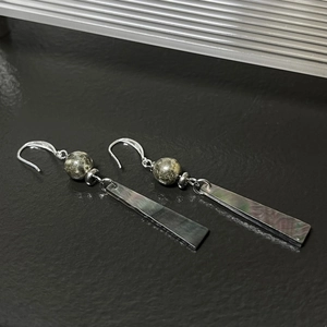 Detailed macro view of S925 silver hooks and dark iridescent rectangular shell earrings