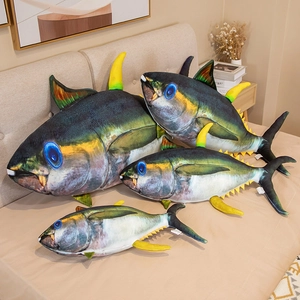 Realistic tuna plush pillows in four sizes displayed on a bed in a cozy home setting