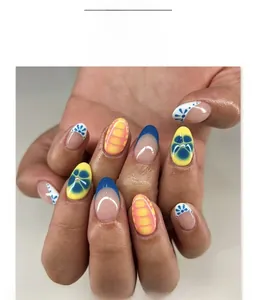 Close-up of French-style press-on nails with blue tips and floral art patterns