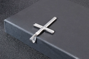 Pendentif croix en acier inoxydable argenté poli présenté sur un coffret noir élégant