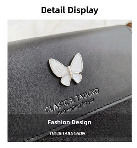 Detail of black pebbled leather bag featuring a white butterfly clasp and embossed text