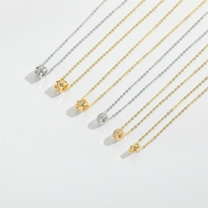 Detail of assorted gold and silver pendant necklaces with zircon and textured patterns