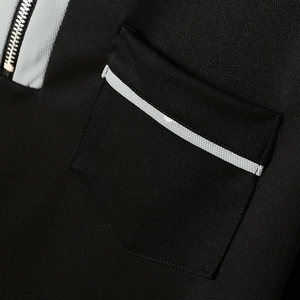 Nahaufnahme des schwarzen Golf-Polos mit texturiertem Stoff, Tasche und Metallreißverschluss