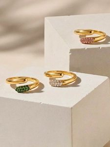 Detail of three gold plated water drop rings with green, white and pink zircon stones