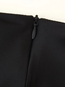Nahaufnahme des verdeckten Reißverschlusses am schwarzen Twill-Spitzenrock