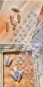 Macro shot of M-945 nail stickers featuring blue butterflies and vintage silver crowns