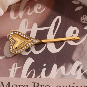 Macro detail of golden heart hair clip with sparkling rhinestones and metallic texture