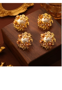 Détail macro de boucles d'oreilles vintage en perles et fleurs métalliques dorées