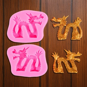 Close-up van roze siliconen drakenvorm en gouden fondant draak met fijne schubben details