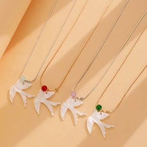 Détail de quatre pendentifs oiseaux sur chaînes or et argent avec perles colorées