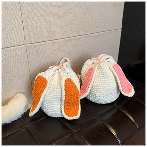 Detail of handmade crochet bunny bucket bags with carrot ears and woven texture