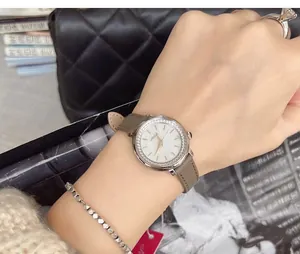 Detail shot of elegant woman's watch with diamond bezel and grey leather strap