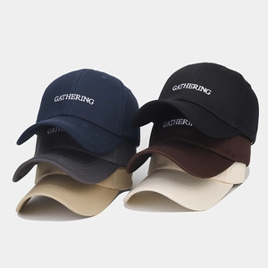 Détail de casquettes de baseball empilées montrant les couleurs et la broderie fine